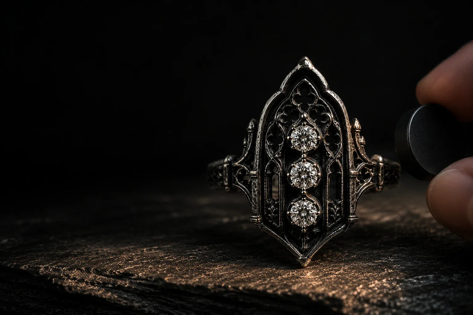 Testing an oxidized sterling silver Gothic ring with a neodymium magnet on dark slate