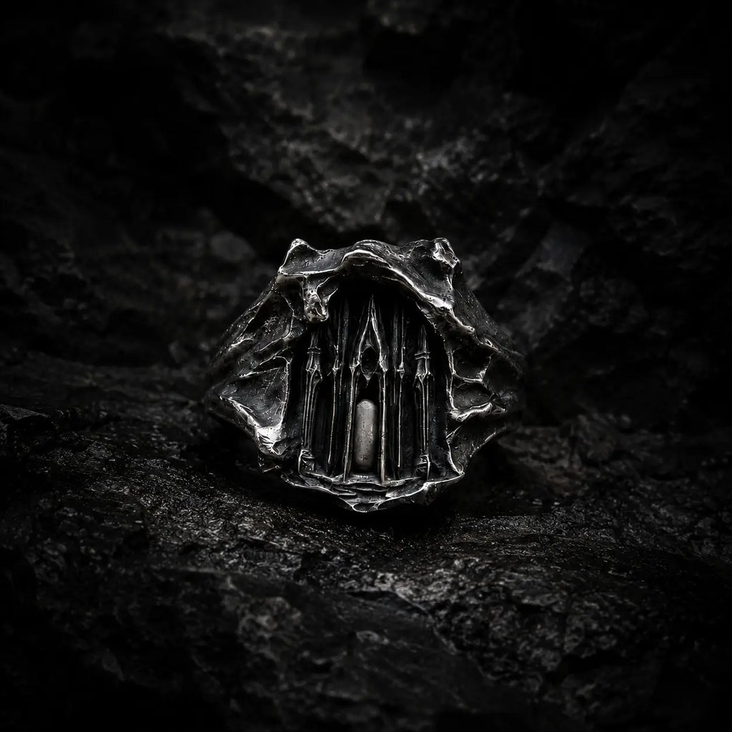 Dark Cathedral Ring — a miniature Gothic cathedral façade carved into raw oxidized 925 sterling silver, front view on dark rock