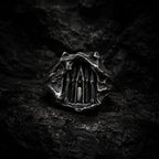 Dark Cathedral Ring — a miniature Gothic cathedral façade carved into raw oxidized 925 sterling silver, front view on dark rock