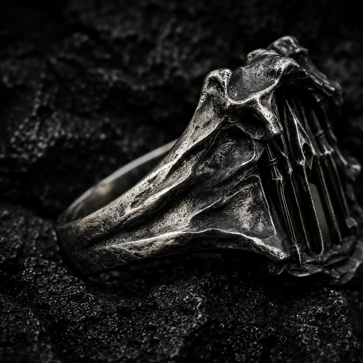 Angled view of the Dark Cathedral Ring showing the rough-hewn sculptural oxidized silver frame
