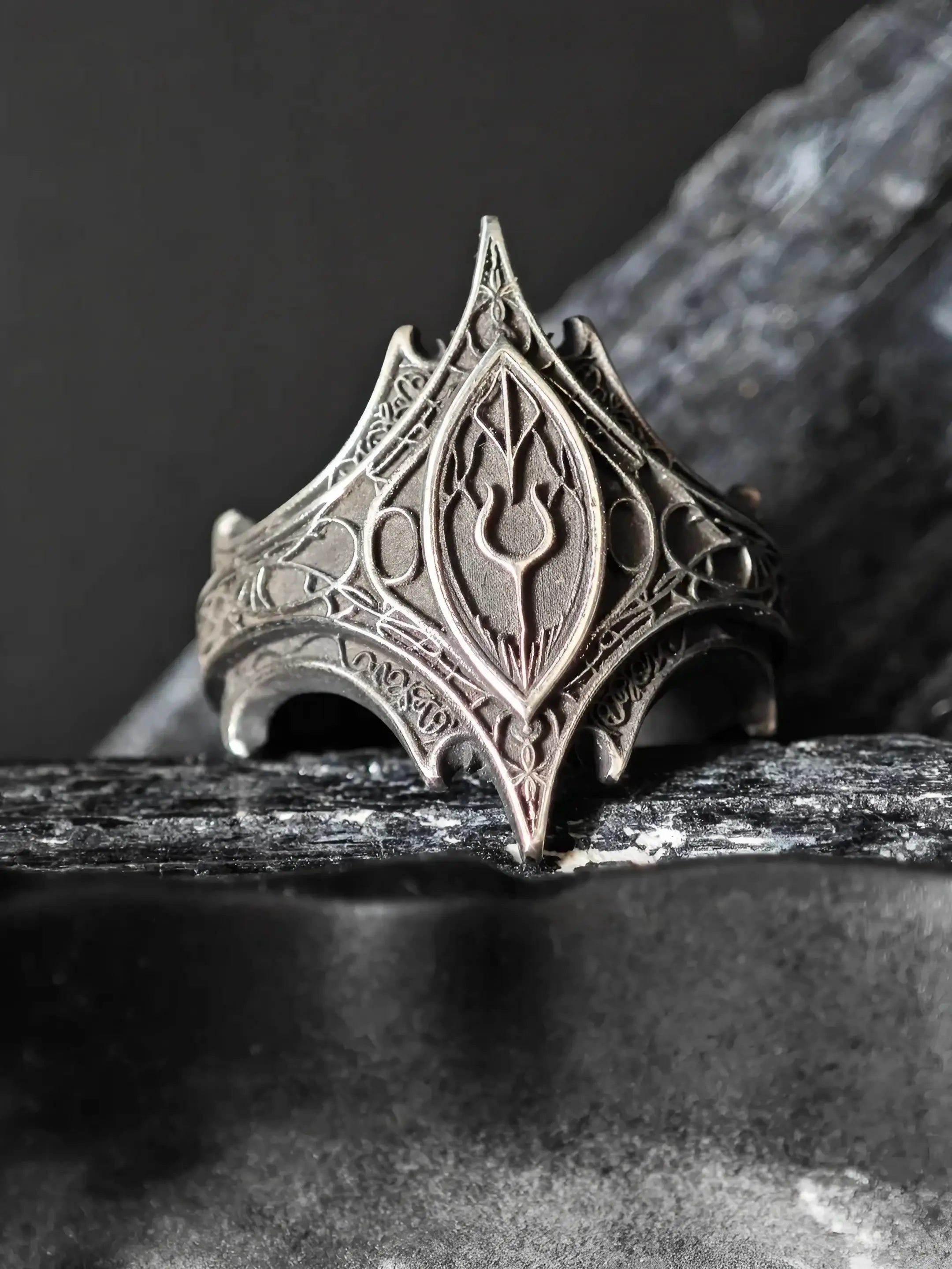 Front view of the Relic Prophecy Ring's engraved rune cartouche and thorned filigree in oxidized silver