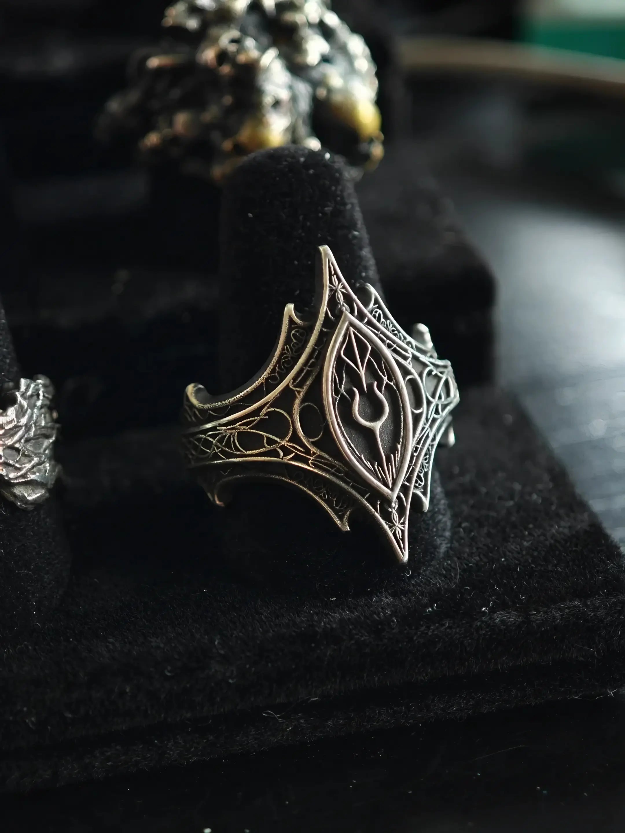 Angled view of the Relic Prophecy Ring on a display stand, hand-carved oxidized 925 sterling silver