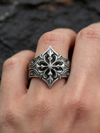 Hand wearing gothic fleur-de-lis cross ring — alternative wedding band with moissanite stone, sterling silver