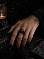 Detail of the Brutalist metal solitaire ring's faceted metal stone and architectural prongs in oxidized silver