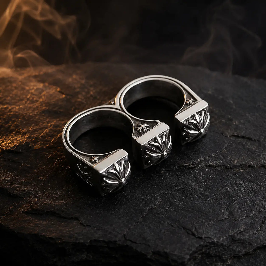 Double Fleur-de-Lis Ring — oxidized sterling silver double-finger biker ring on dark stone