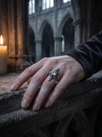 Midnight Star Neo-Gothic ring worn on hand resting on stone railing in a gothic cathedral