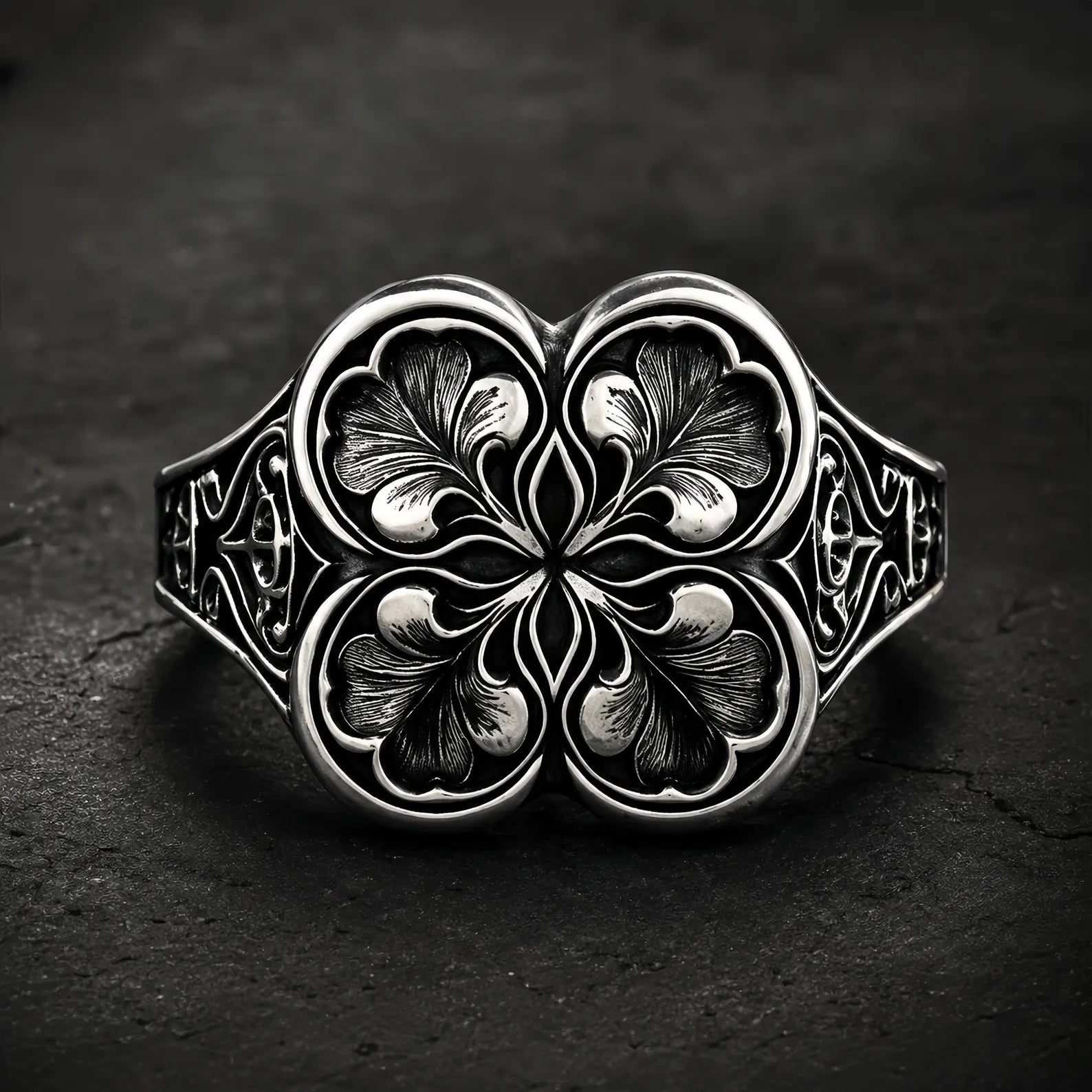 Gothic clover ring — sterling silver quatrefoil engraving, front view on dark stone backdrop