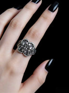 Hand wearing gothic sterling silver clover ring — dark romantic statement jewelry
