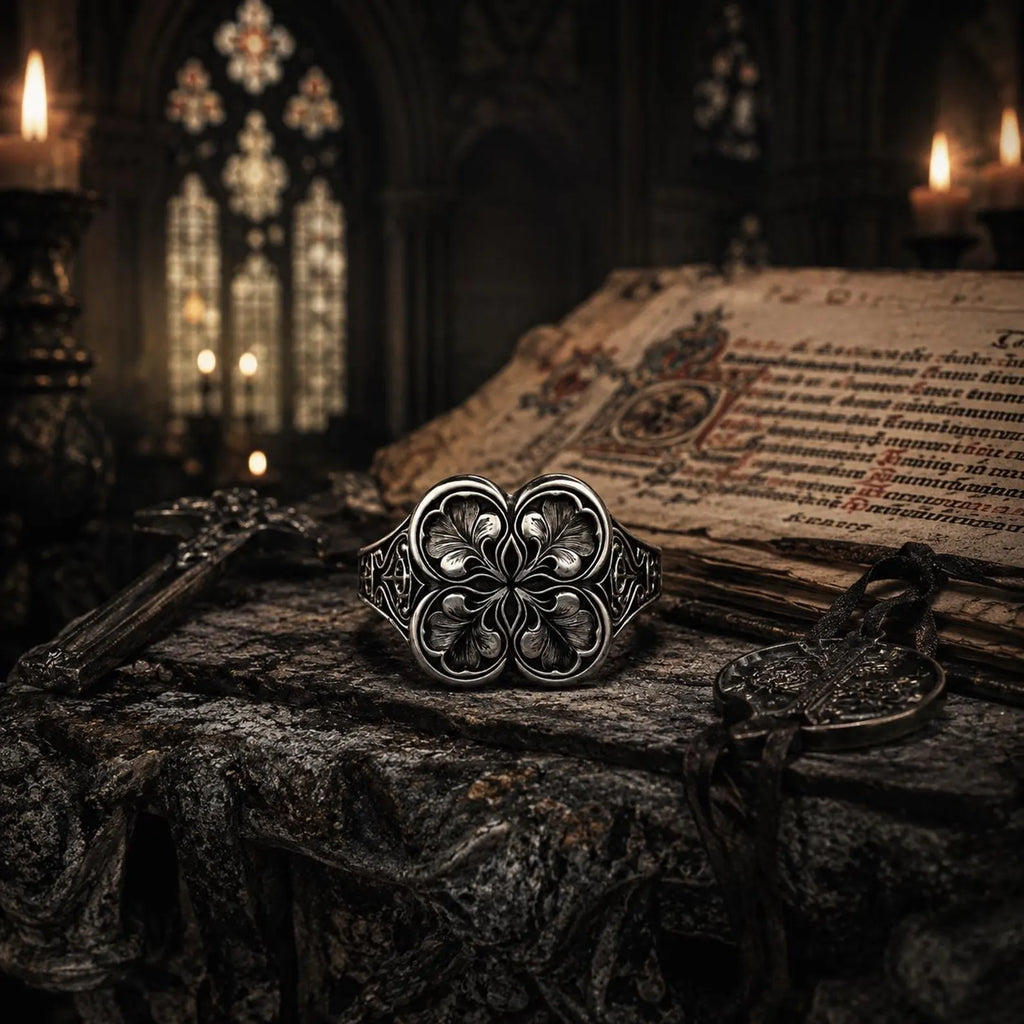 Gothic clover ring close angle — oxidized sterling silver quatrefoil engraving beside candlelight