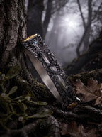 Silver Sword Swiss Blue Topaz Celtic cuff leaning against mossy tree trunk in forest