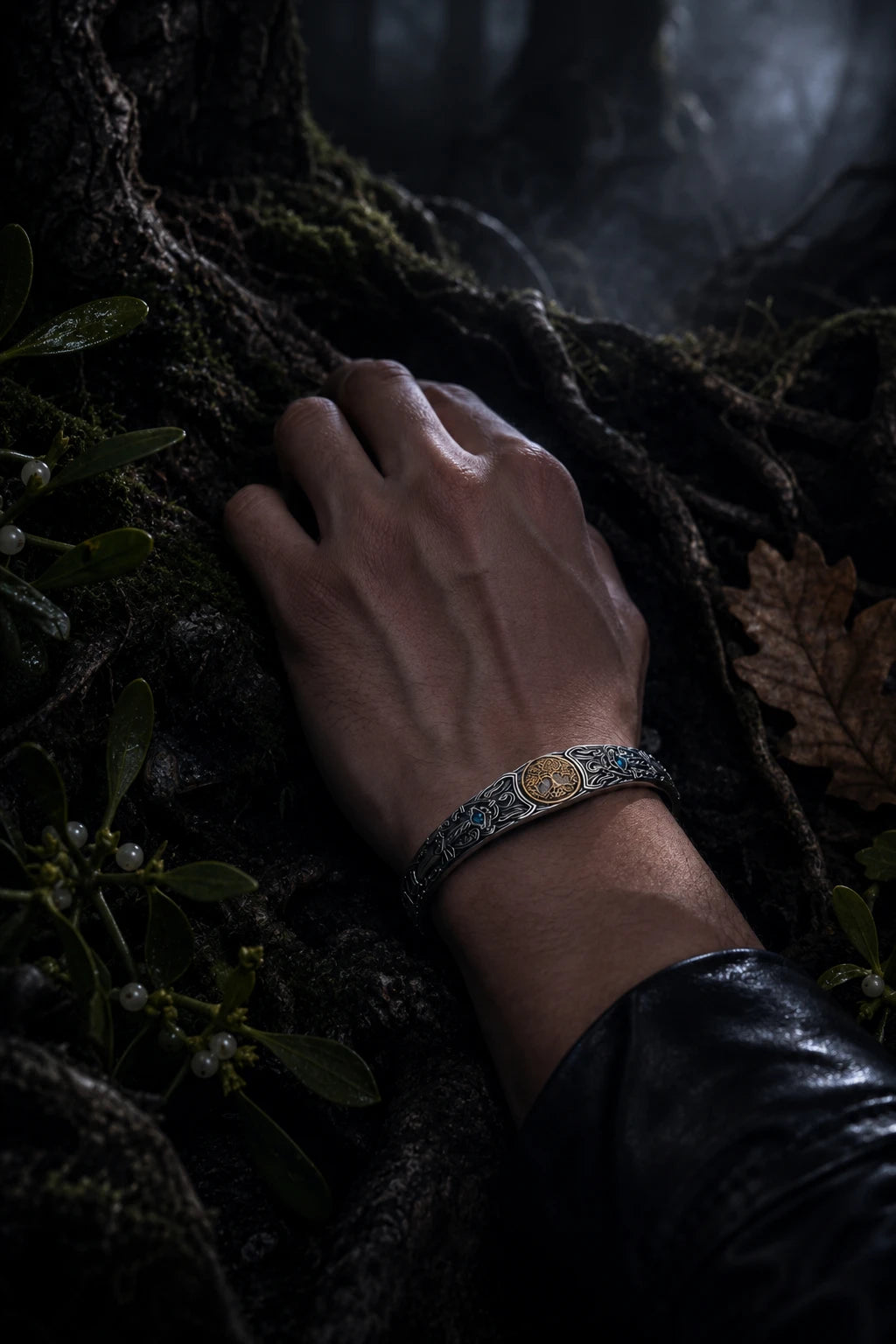 Silver Sword Swiss Blue Topaz Celtic cuff worn on wrist resting on mossy tree roots