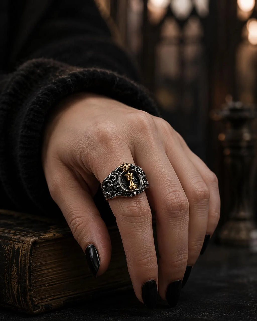 Detail of the gold queen chess piece and crown on the Chess Queen Ring against a blackened ground