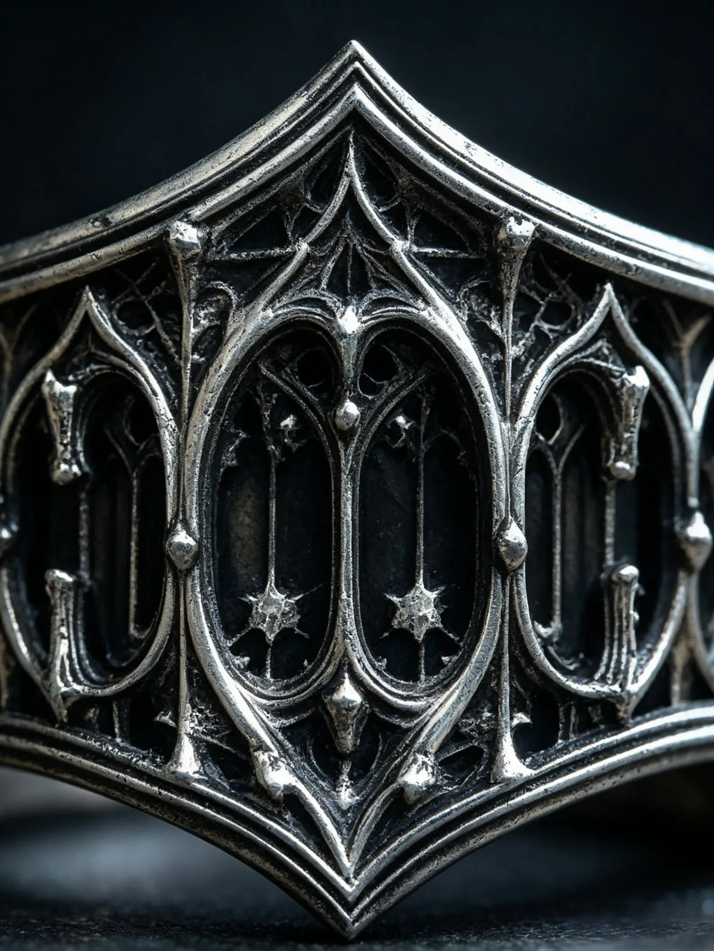 Macro detail of the carved Gothic lancet-window tracery and star motifs on the sterling silver band