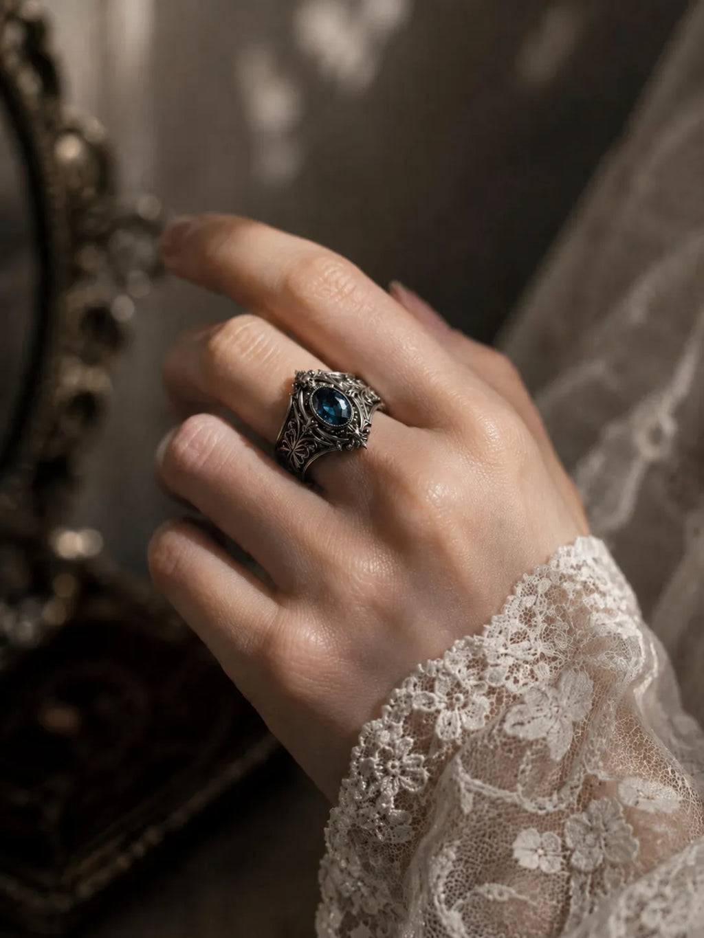 Hand wearing Victorian memento mori skull ring with blue topaz — gothic alternative engagement ring in 925 silver