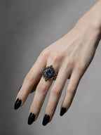 Hand wearing gothic cathedral sanctuary ring with blue topaz — alternative engagement ring in sterling silver